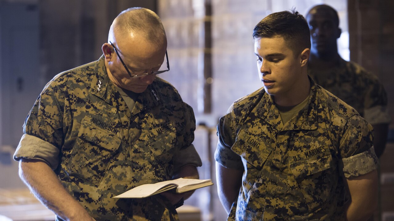 U.S. Marine Corps Lt. Gen. Lawrence D. Nicholson, Left, the commanding general for III Marine Expeditionary Force, reviews Cpl. Matthew A. Long’s, Right, a motor transport mechanic with Motor Transport Company, 3rd Marine Logistics Group, III MEF, design for a self-aiding device to be attached to the small arms protective insert plates worn by Marines in combat on Camp Kinser, Okinawa, Japan, Oct. 20, 2016. Long was selected as a winner in a Marine Corps wide competition for logistical innovation. Long came up with the design in attempt to save Marines’ lives in combat by minimizing the amount of time between being injuring and receiving aid.