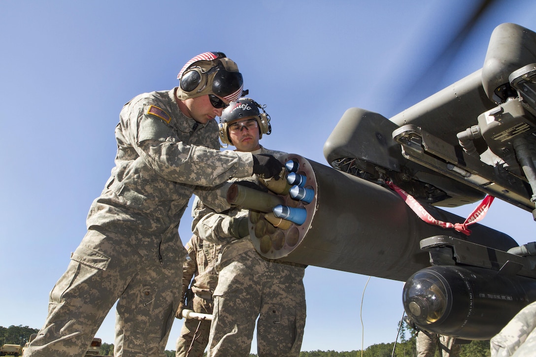 Army Capt. Tyler Reynolds, left, plugs a rocket fuse into the rocket pod on an AH-64D Apache helicopter during an aerial gunnery exercise at Fort Stewart, Ga, Oct. 22, 2016. Reynolds commands Troop D, 3rd Squadron, 17th Cavalry Regiment. Army photo by Spc. Scott Lindblom