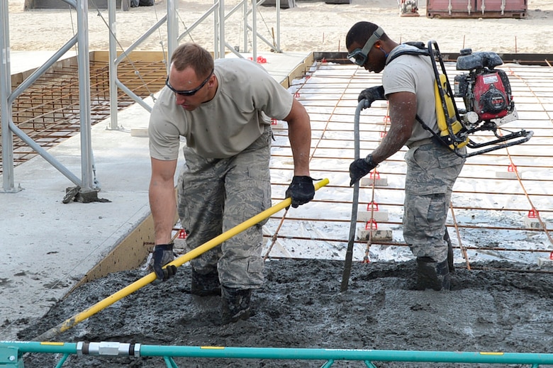 Staff Sgt. Cameron Kruell, left, and Airman 1st Class Marco Small-Gonzalez, 386th Expeditionary Civil Engineering Squadron pavements and equipment technicians, lay concrete on the flightline at an undisclosed location in Southwest Asia 24 Oct., 2016. The 386th ECES is expanding sunshades to prepare for an upcoming transition from MQ-1 Predators to MQ-9 Reapers. (U.S. Air Force photo by Capt. Casey Osborne/Released)