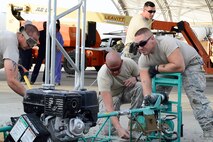 From left, Senior Airman Victor Granger, Tech. Sgt. David Torres and Airman 1st Class Matthew Fleming, 386th Expeditionary Civil Engineering Squadron pavements and equipment technicians, smooth out concrete at an undisclosed location in Southwest Asia 24 Oct., 2016. The 386th ECES is expanding sunshades to prepare for an upcoming transition from MQ-1 Predators to MQ-9 Reapers. (U.S. Air Force photo by Capt. Casey Osborne/Released)