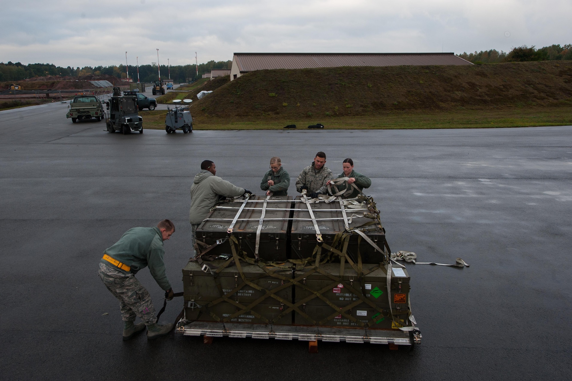 Airmen from the 86th Munitions Squadron properly secure boxes of ammunition as part of an exercise at Ramstein Air Base, Germany, Oct. 25, 2016. The exercise pushed Airmen to perform jobs as effective and quick as possible, such as safely wrapping and loading boxes of ammunition into storage containers. (U.S. Air Force photo by Airman 1st Class Lane T. Plummer)