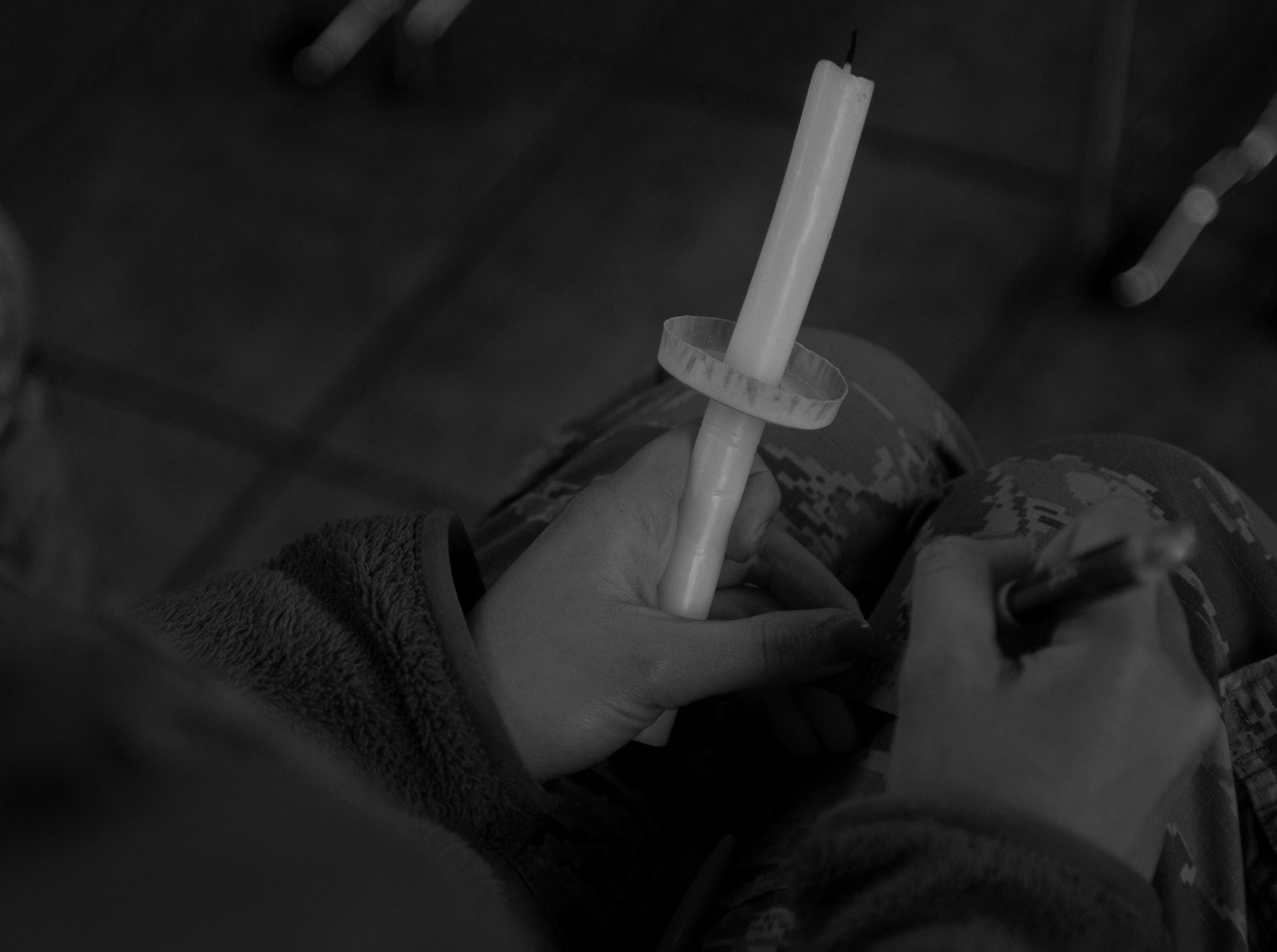 A participant attending a candlelight vigil writes down the name belonging to a victim of interpersonal violence at Ramstein Air Base, Germany, Oct. 27, 2016. Those who took part in the vigil put the names they’d written into a glass jar and then lit their candle they were given by one of the four differently-marked candles surrounding the jar. According to the Center for Disease Control and Prevention, over the course of a year, more than 10 million U.S. citizens are victims of domestic violence, sexual abuse, child violence and bullying or suicide. The devastating physical, emotional, and psychological consequences of interpersonal violence can cross generations and last lifetimes. (U.S. Air Force photo by Airman 1st Class Lane T. Plummer)
