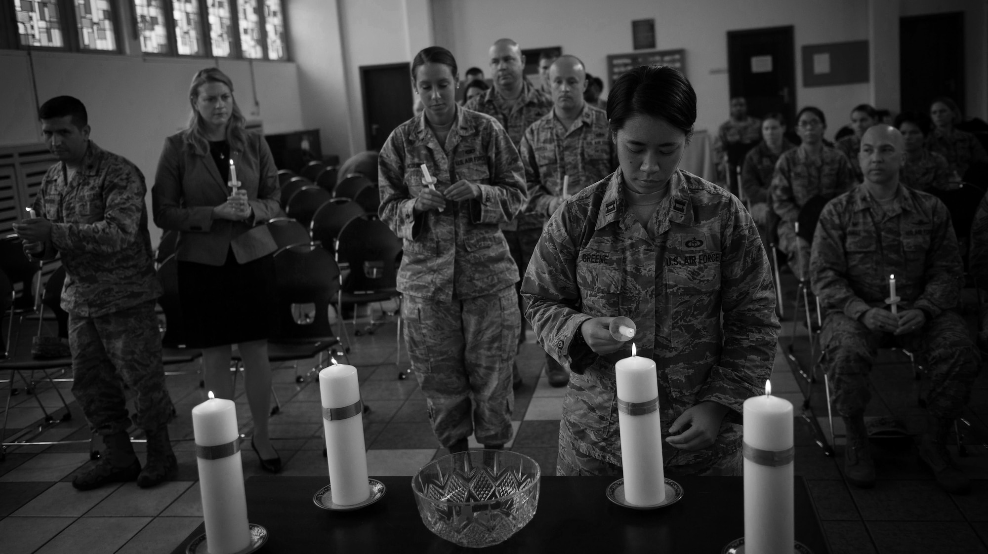 An Airman lights her candle in honor of a victim of interpersonal violence during a candlelight vigil at Ramstein Air Base, Germany, Oct. 27, 2016. According to the Center for Disease Control and Prevention, over the course of a year, more than 10 million U.S. citizens are victims of domestic violence, sexual abuse, child violence and bullying or suicide. The devastating physical, emotional, and psychological consequences of interpersonal violence can cross generations and last lifetimes. (U.S. Air Force photo by Airman 1st Class Lane T. Plummer)