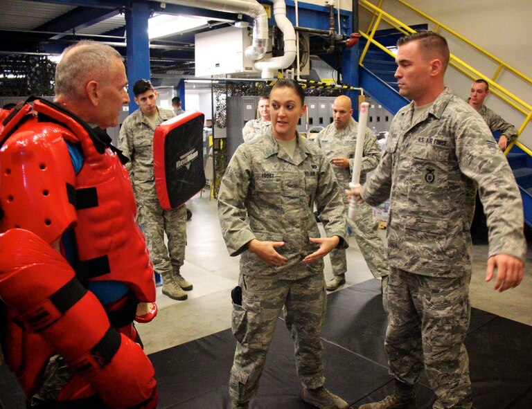 Col. Jonathan Philebaum, commander of the 932nd Airlift Wing in protective suit at left, listens to instructions from Senior Airman Nicole Frost, as he begins to play the part of a simulated attacker during training.  The goal was to help security forces understand physical techniques to use while their "guest" played the role of the aggressor, during baton training at Scott Air Force Base, Illinois, Oct. 1, 2016. The suit is designed so that baton trainees are able strike without causing injury. After wearing the suit for several rounds of training, Philebaum said, "I'm glad that I'm on the 932nd Security Forces defender team because they all know what they are doing and get the job done right the first time." (U.S. Air Force photo by Lt. Col. Stan Paregien)