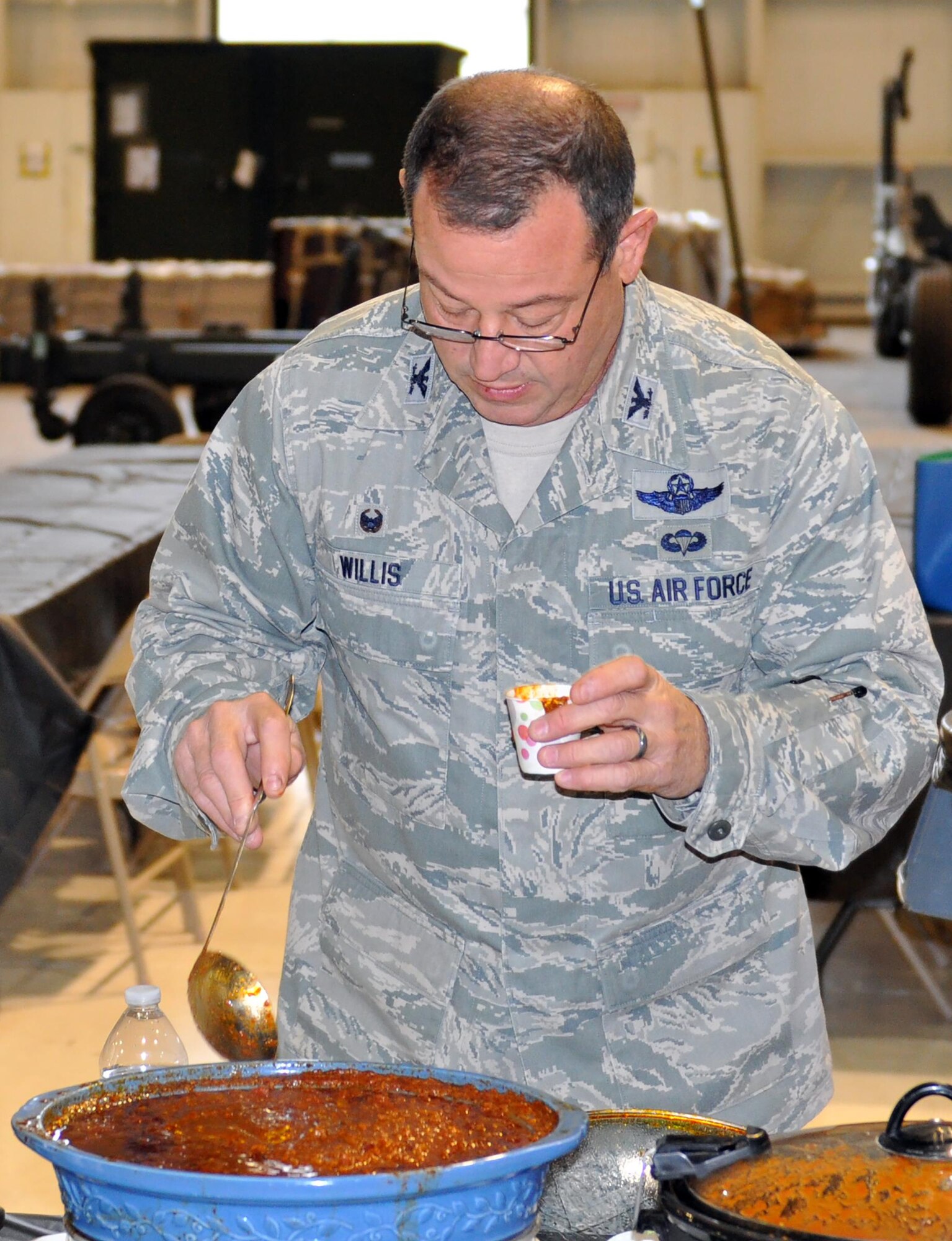 Col. Adam Willis, 445th Airlift Wing commander, samples one of 17 pots of chili while serving as a judge during the 445th Airlift Wing’s 16th Annual Chili Cook-off Oct. 27, 2016. The event raised $400 for the Combined Federal Campaign. (U.S. Air Force photo/Lt. Col. Cynthia Harris)