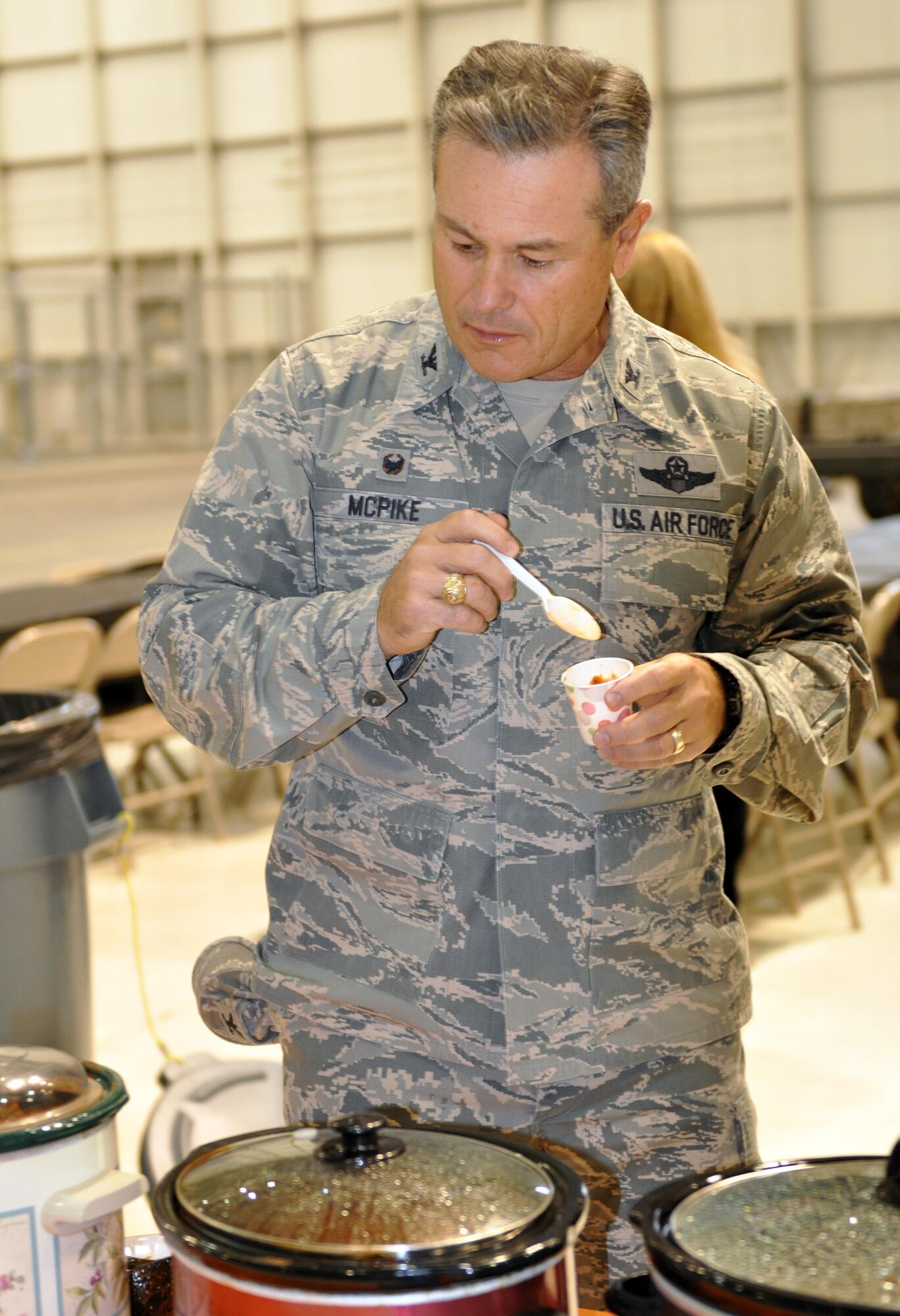 Col. Craig McPike, 445th Operations Group commander, samples one of 17 pots of chili while serving as a judge during the 445th Airlift Wing’s 16th Annual Chili Cook-off Oct. 27, 2016. The event raised $400 for the Combined Federal Campaign. (U.S. Air Force photo/Stacy Vaughn)    