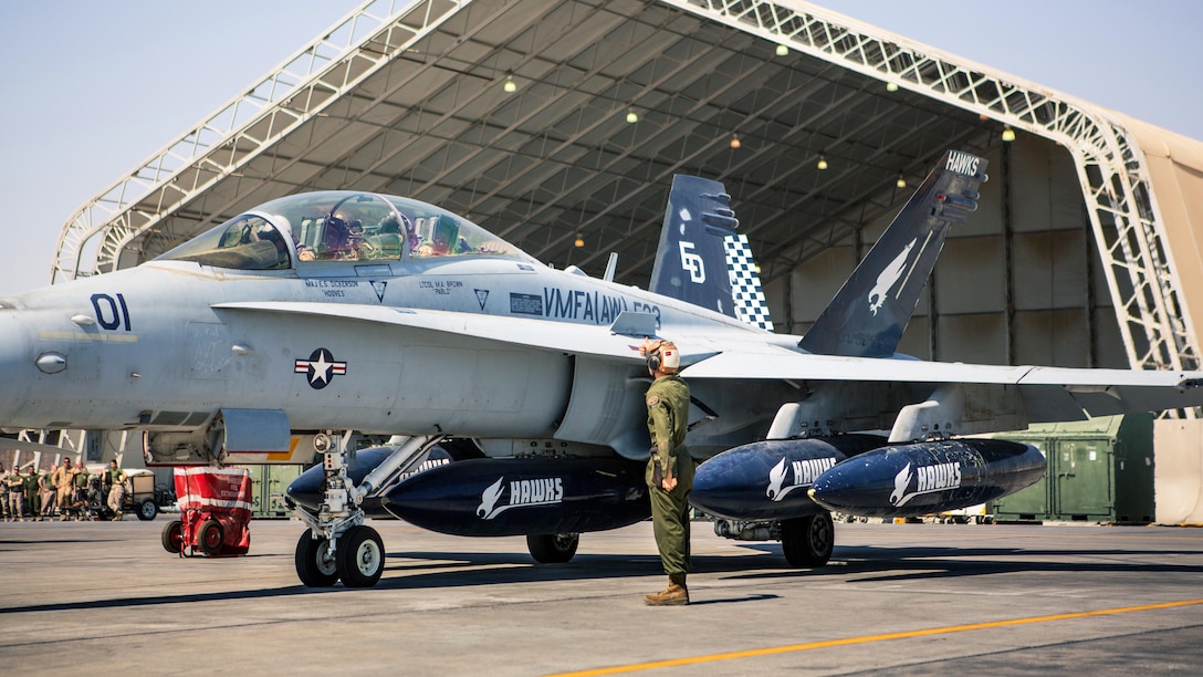 A U.S. Marine with Marine All-Weather Fighter Attack Squadron 533, Special Purpose Marine Air-Ground Task Force 16.2, directs an F/A-18D prior to takeoff at an undisclosed location in Southwest Asia, Oct. 15, 2016. VMFA(AW)-533 departed the CENTCOM area of responsibility, completing deployment as part of the Aviation Combat Element of SPMAGTF-CR-CC.  The squadron conducted strikes in support of Operation Inherent Resolve, the operation to eliminate the ISIL terrorist group and the threat they pose to Iraq, Syria, and the wider international community. (U.S. Marine Corps photo by Sgt. Donald Holbert)