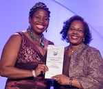 DETROIT, Mich. – Navy engineer Tiffany Owens, left, receives the Women of Color Magazine’s 2016 Community Service Award at the magazine’s annual awards gala held at the Detroit Marriott in the Renaissance Center, Oct. 15. Owens was honored for inspiring and mentoring students throughout Virginia in a myriad of science, technology, engineering and mathematics programs. “In serving our country as a systems safety engineer at the Naval Surface Warfare Center Dahlgren Division, Tiffany Owens has also gone above and beyond in service to her community,” said Karen Davis, Naval Sea Systems Command Executive Director for Surface Warfare, told the audience before presenting the award to Owens.