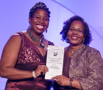 DETROIT, Mich. – Navy engineer Tiffany Owens, left, receives the Women of Color Magazine’s 2016 Community Service Award at the magazine’s annual awards gala held at the Detroit Marriott in the Renaissance Center, Oct. 15. Owens was honored for inspiring and mentoring students throughout Virginia in a myriad of science, technology, engineering and mathematics programs. “In serving our country as a systems safety engineer at the Naval Surface Warfare Center Dahlgren Division, Tiffany Owens has also gone above and beyond in service to her community,” said Karen Davis, Naval Sea Systems Command Executive Director for Surface Warfare, told the audience before presenting the award to Owens.