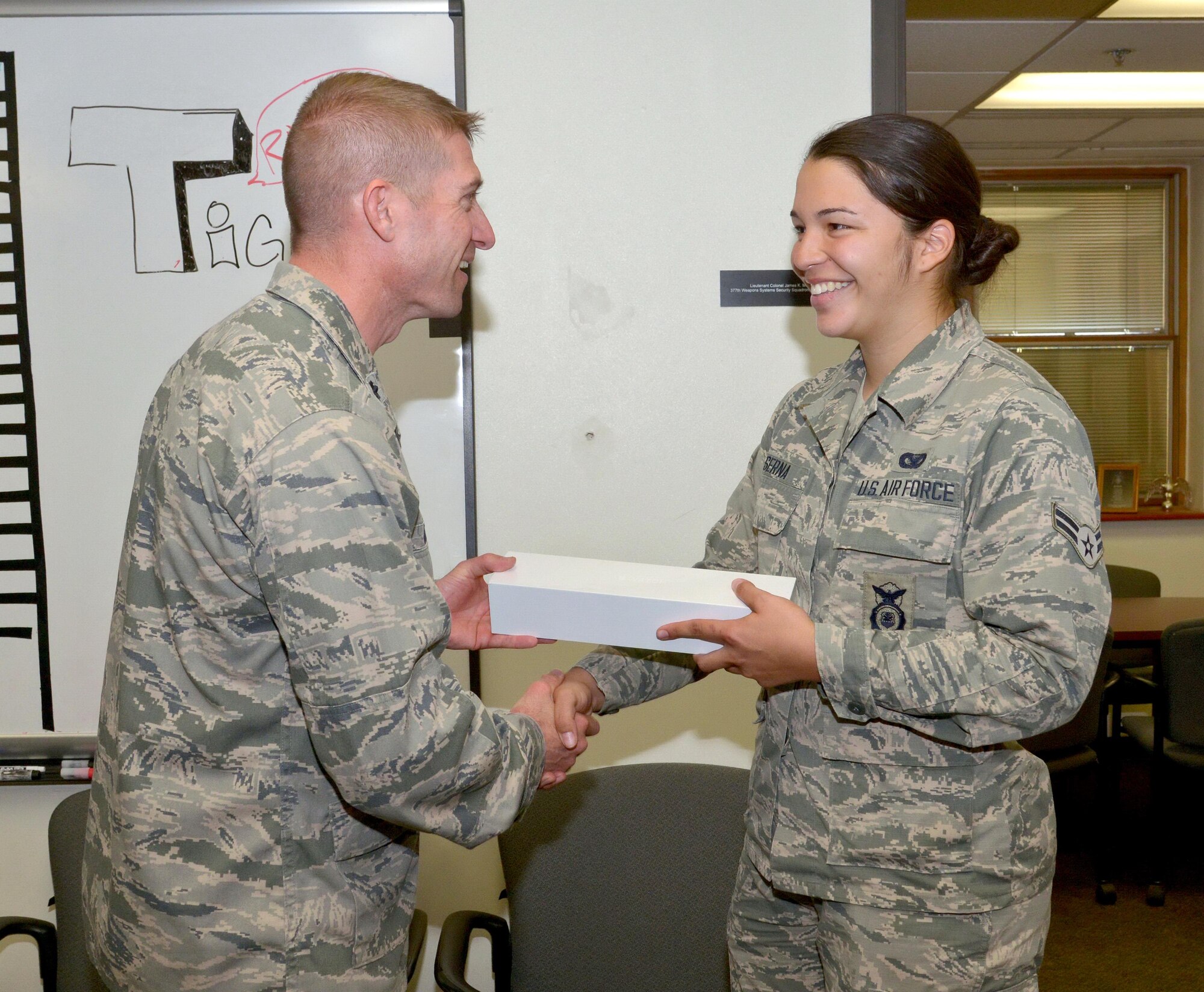 Lt. Col. James Meier, 377th Weapons System Security Squadron commander, presents an Apple iWatch to Airman 1st Class Alejandra Serna. Serna won the prize for her participation in the 37th Training Wing's 2016 Innovation Day. Of about 1,200 Airmen in that wing, she was the only one to visit every demonstrated showcase. (Photo by Jamie Burnett)