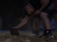 The 2nd Maintenance Squadron team center holds the ball and is ready to snap it to the quarterback at Barksdale Air Force Base, La., Oct. 25, 2016. The offense has to cross the nearest 20 or 40 yard line in front of them to get a first down. (U.S. Air Force photo/Airman 1st Class Stuart Bright)