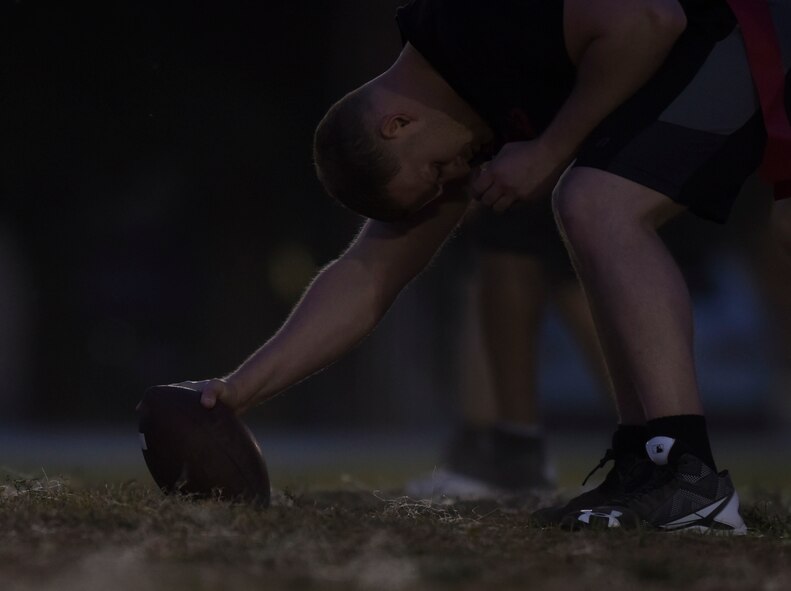 The 2nd Maintenance Squadron team center holds the ball and is ready to snap it to the quarterback at Barksdale Air Force Base, La., Oct. 25, 2016. The offense has to cross the nearest 20 or 40 yard line in front of them to get a first down. (U.S. Air Force photo/Airman 1st Class Stuart Bright)