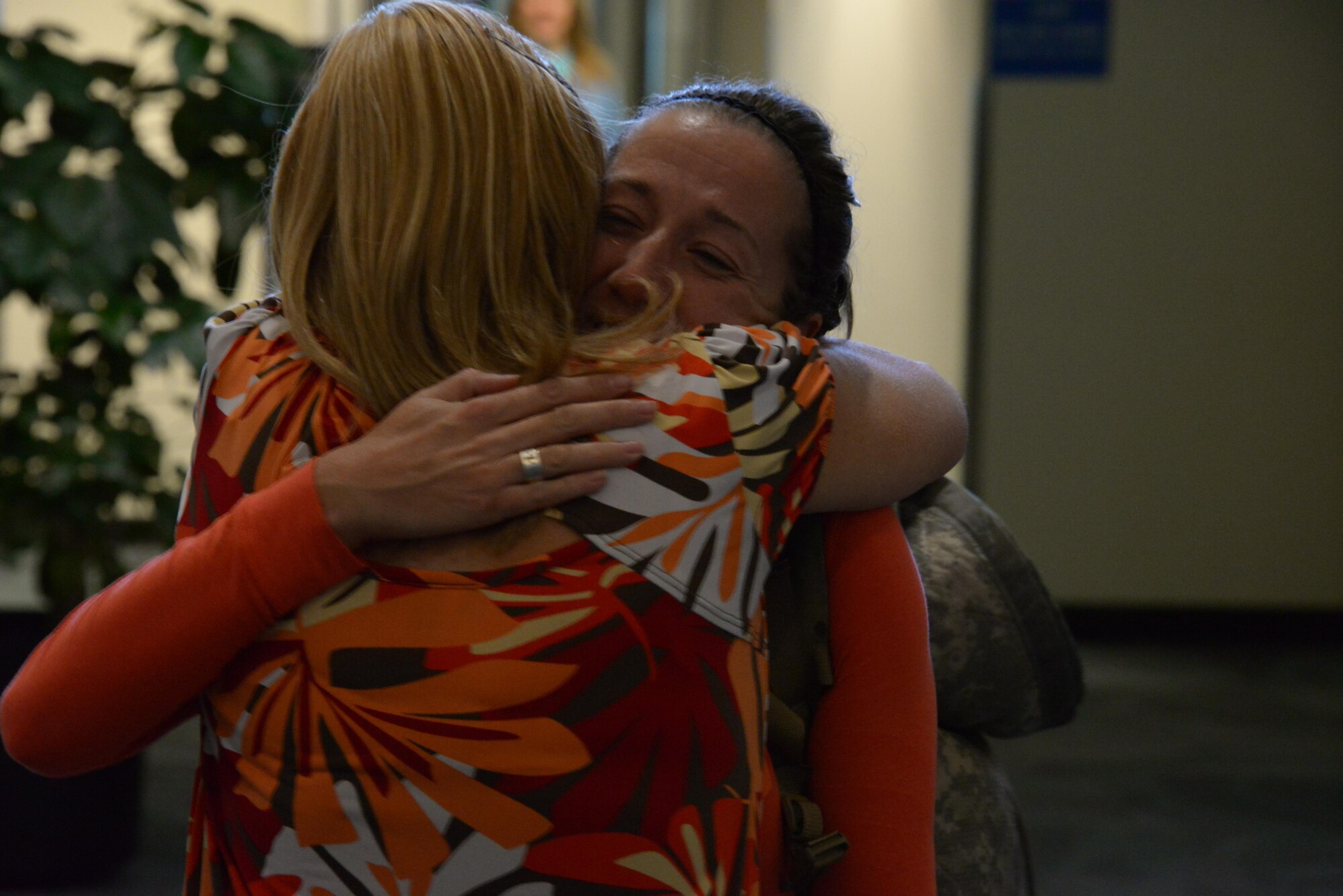 Tech. Sgt. Brianna Oberg embraces her co-worker, Candace Akerson, after returning from a deployment, Oct. 28, 2016. Air University Headquarters planned a welcoming party at the airport, gathering 16 Airmen to see their returned office member.  (U.S. Air Force photo by Senior Airman William Blankenship)