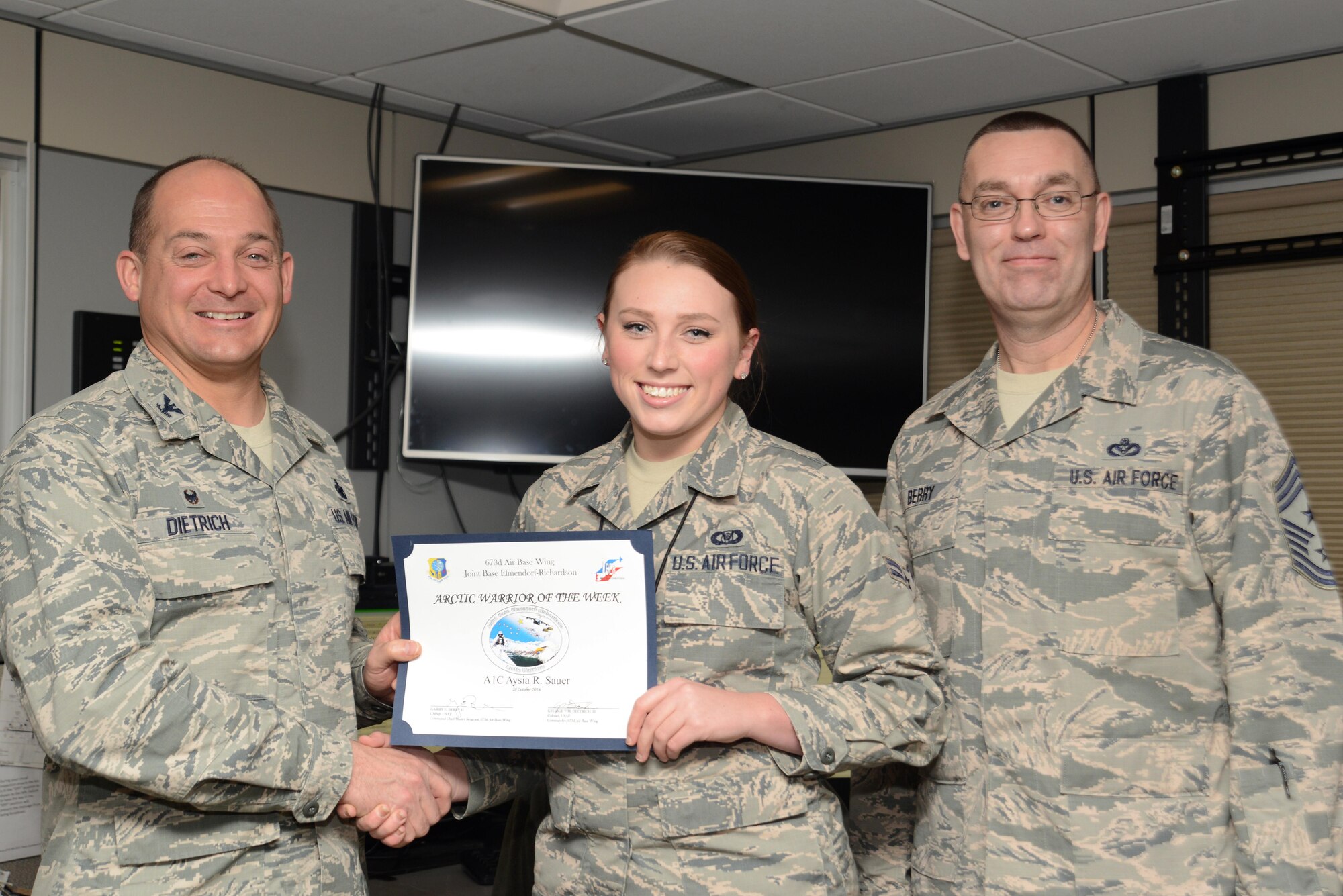 Airman 1st Class Aysia Sauer, 673d Command Post emergency action controller, receives the Arctic Warrior of the Week at Joint Base Elmendorf-Richardson, Alaska, Oct. 28, 2016.