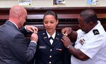 2nd Lt. Katrina Fay Simpson receives her artillery shoulder boards from her husband Mike Simpson and father, retired Chief Warrant Officer 2 Cornelius James Ware, during a New Hampshire Army National Guard commissioning ceremony Sept.11, 2015, at the State House in Concord. 