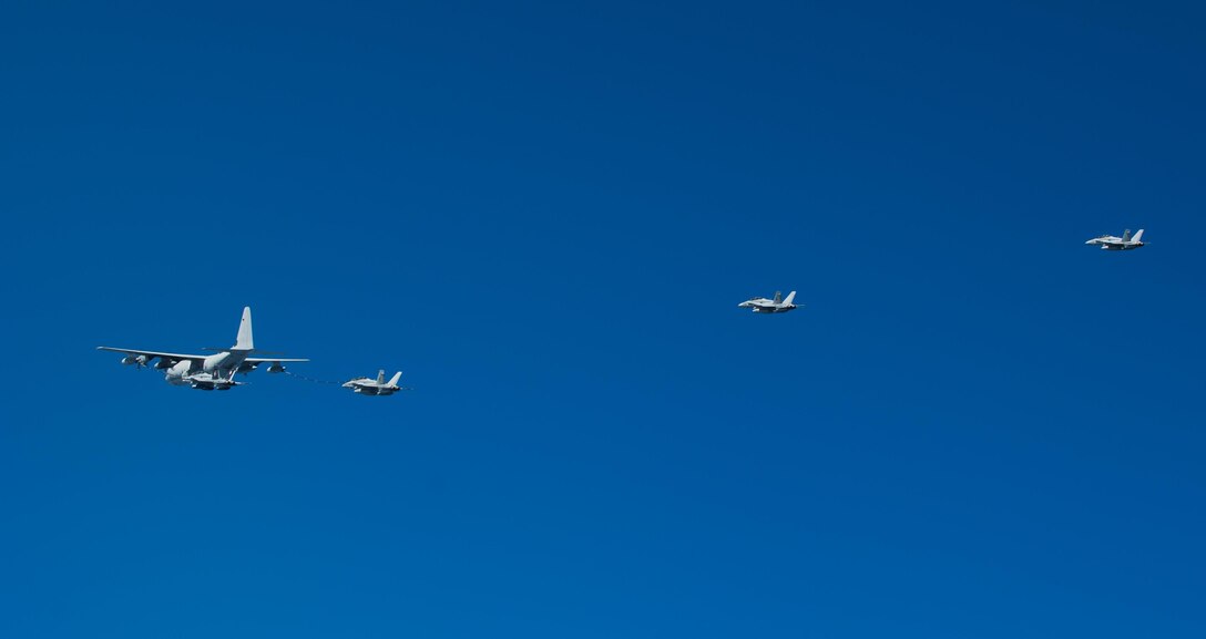 A KC-130J with Marine Aerial Refueler Transport Squadron 352, flies in front of multiple F/A-18 Hornets during a Special Purpose Marine Air-Ground Task Force - Crisis Response - Central Command aerial refueling exercise, Oct. 13, 2016. SPMAGTF-CR-CC is a self-sustaining expeditionary unit, designed to provide a broad range of crisis response capabilities throughout the Central Command area of responsibility, using organic aviation, logistical, and ground combat assets, to include TRAP and embassy reinforcement. (U.S. Marine Corps photo by Cpl. Trever Statz)