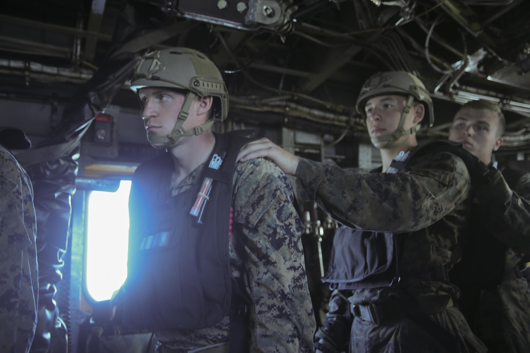 Marines line up before soft-ducking, or dropping out an aircraft with a zodiac boat, during a helocasting exercise at Camp Lejeune, N.C., Oct. 20, 2016. They are required to know hand-and-arm signals to let them communicate before dropping into the water for sea to shore movements. The Marines are with 2nd Reconnaissance Battalion. (U.S. Marine Corps photo by Lance Cpl. Miranda Faughn)