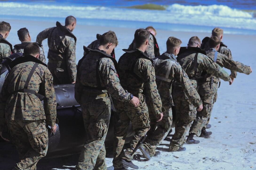 Marines carry a zodiac boat into the waves of Onslow Beach at Camp Lejeune, N.C., Oct. 20, 2016. These Marines conducted helocasting, practicing being inserted from a helicopter with a zodiac boat as well as a movement to shore without a boat for a scout swimmer fin insertion. The Marines are with 2nd Reconnaissance Battalion. (U.S. Marine Corps photo by Lance Cpl. Miranda Faughn)