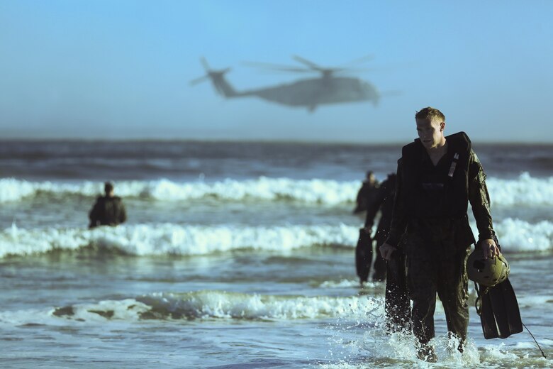 Marines emerge from the surf after dropping from a CH-53E Super Stallion and swimming ashore as part of a scout swimmer fin insertion during a helocasting exercise at Camp Lejeune, N.C., Oct. 20, 2016. During the exercise the Marines also practiced dropping with a zodiac boat, also known as soft-ducking, a means of insertion for sea to shore reconnaissance operations. These Marines are with 2nd Reconnaissance Battalion. (U.S. Marine Corps photo by Lance Cpl. Miranda Faughn)