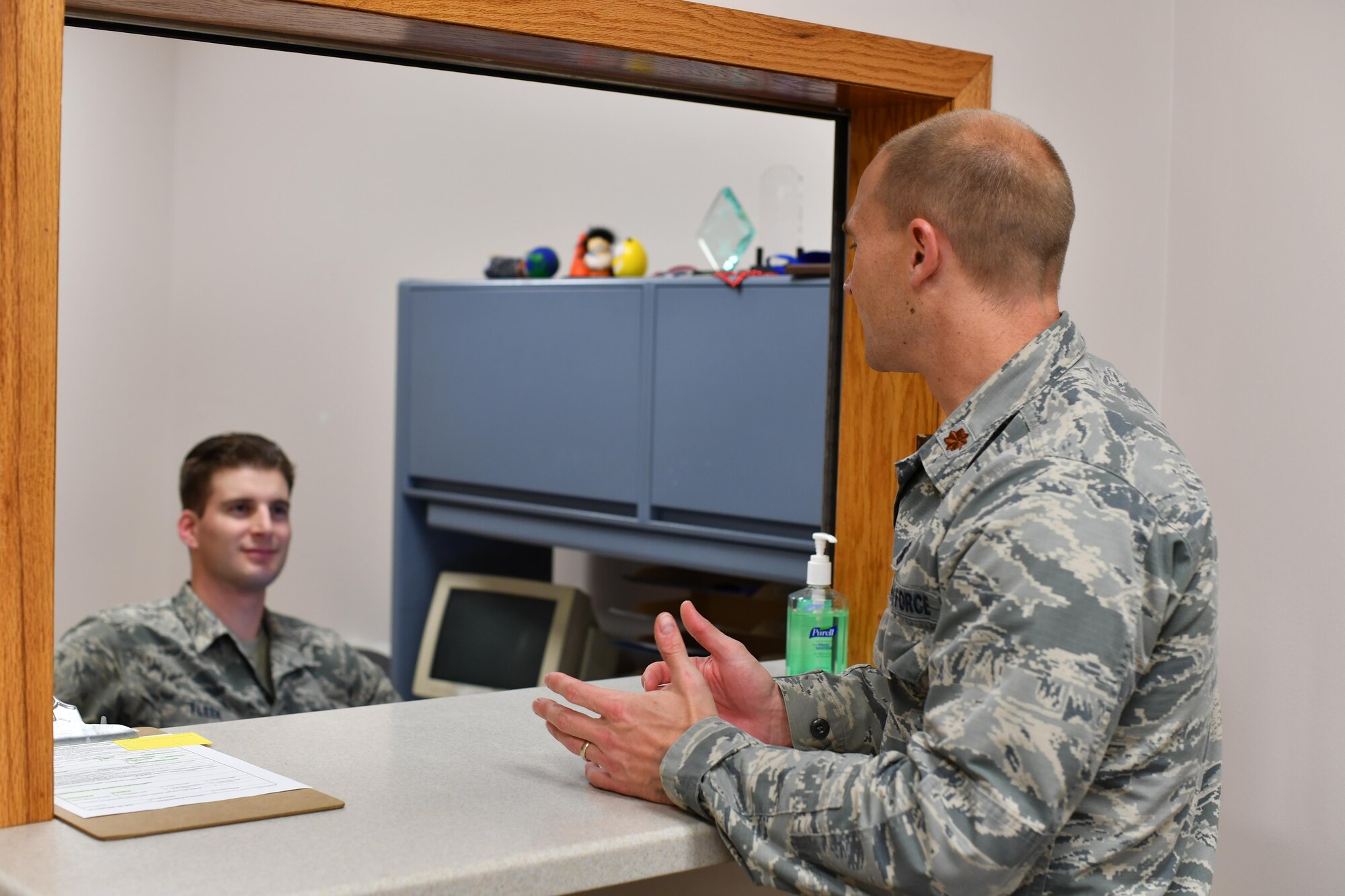 SrA Joshua Fleek, 319th Medical Group x-ray technologist, and Maj. Corby Heyne, 319th Medical Group medical information systems and resources flight commander, converse Oct. 26, 2016, in the Medical Treatment Facility on Grand Forks Air Force Base, N.D. Heyne is leading the Patient and Family Engagement initiative at Grand Forks AFB to provide higher quality service to patients. (U.S. Air Force photo by Airman 1st Class Elijaih Tiggs)