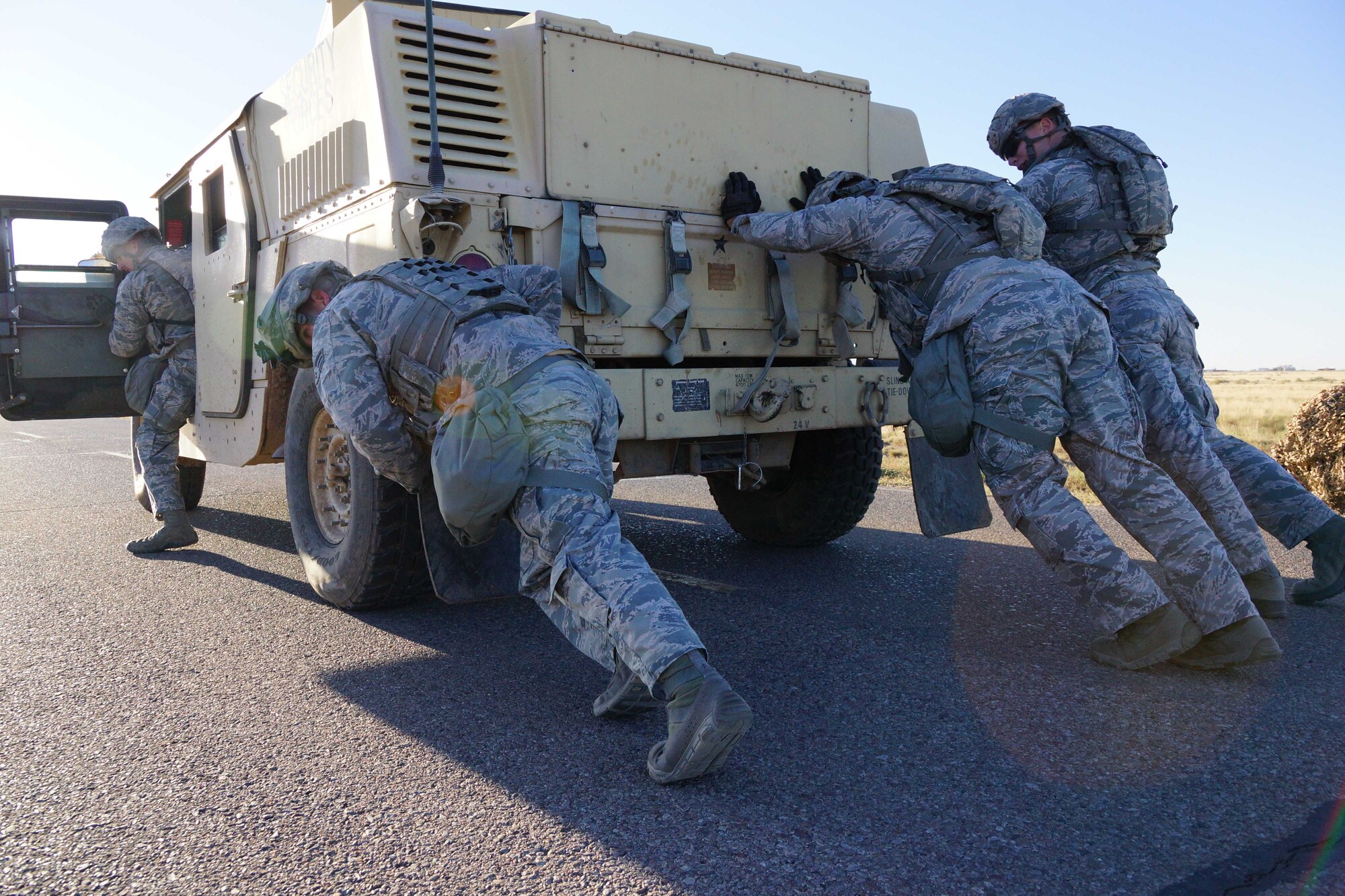 Members of 377th Security Forces Squadron push a Humvee during a skills test at the first-ever Manzano Challenge Oct. 22 at  Kirtland. The event saw 64 Airmen competing in different stations, ranging from weapons skills and land navigation to team tactics and problem solving. 