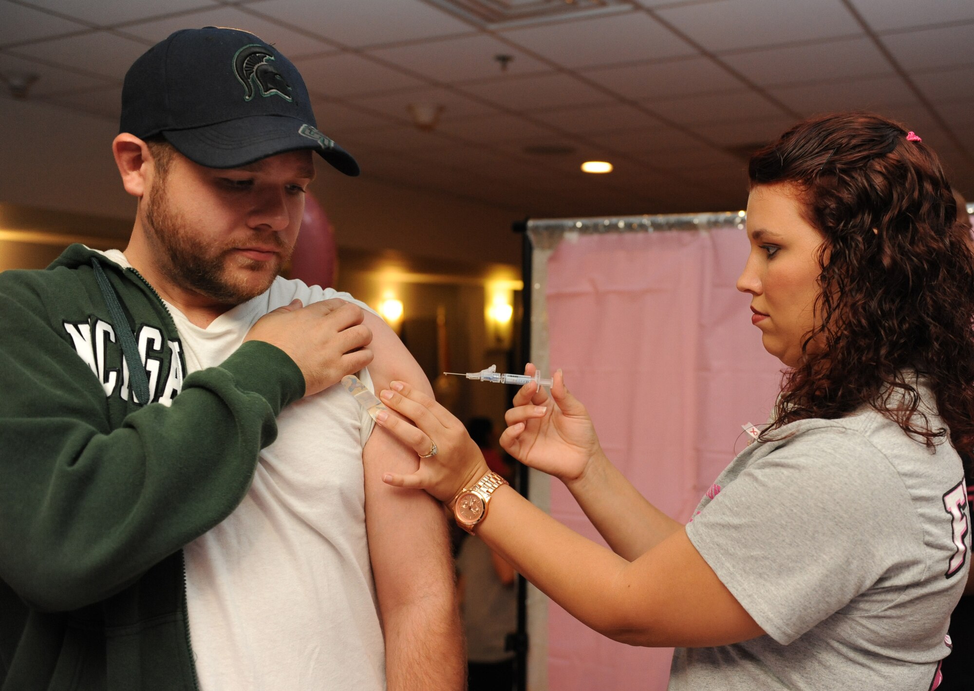 Aharon DeMaeyer, spouse of Master Sgt. Stephanie DeMaeyer, 81st Medical Support Squadron medical group security manager, receives a flu shot from Senior Airman Britani Adkison, 81st Medical Operations Squadron immunization technician, during the 5th Annual Mammothon Cancer Screening and Preventative Health Fair at the Don Wylie Auditorium Oct. 28, 2016, on Keesler Air Force Base, Miss. The walk-in event included screenings for multiple types of cancer and chronic diseases in honor of Breast Cancer Awareness Month. Flu shots were also provided upon request. (U.S. Air Force photo by Kemberly Groue/Released)