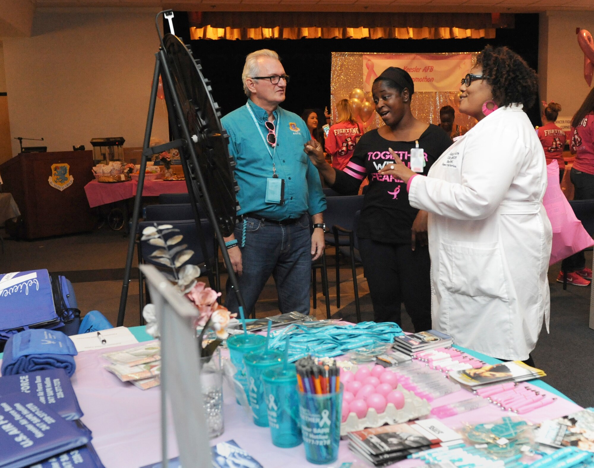 Barry Newman, 81st Training Wing Sexual Assault Prevention and Response Program specialist, provides SAPR information to Maj. Melinda Williamson, 81st Medical Operations Squadron registered nurse, and Yolanda Moulds-Love, 81st Diagnostic and Therapeutics Squadron clinical pharmacist, during the 5th Annual Mammothon Cancer Screening and Preventative Health Fair at the Don Wylie Auditorium Oct. 28, 2016, on Keesler Air Force Base, Miss. The walk-in event included screenings for multiple types of cancer and chronic diseases in honor of Breast Cancer Awareness Month. Flu shots were also provided upon request. (U.S. Air Force photo by Kemberly Groue/Released)