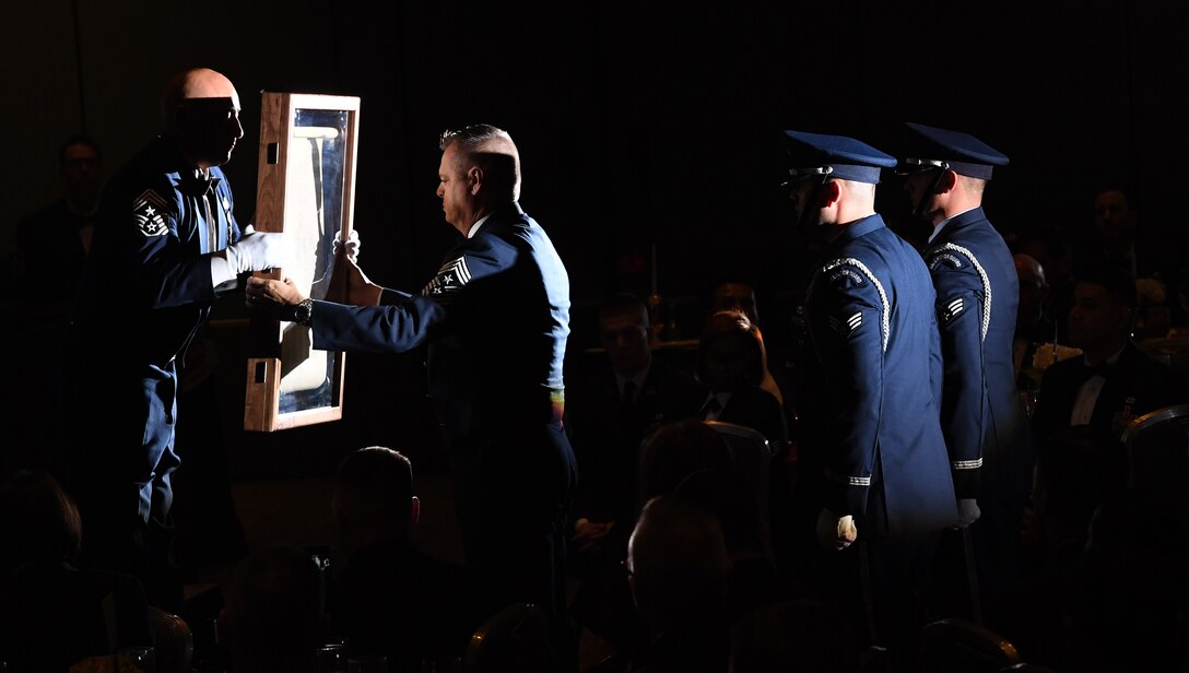 Chief Master Sgt. Jose A. Baraza, 12th Air Force command chief, Davis-Monthan Air Force Base, Ariz., hands an Order of the Sword scroll to Chief Master Sgt. Joseph Montgomery, command chief of U.S. Air Forces Central Command during an order of the sword ceremony at the Hampton Roads Convention Center in Hampton, Va., Oct. 27, 2016. U.S. Air Force NCOs revised and updated the Order of the Sword ceremony and adopted it in 1967. Since then, the rare honor of receiving it has only been accorded to those special leaders who demonstrate extraordinary support for the enlisted corps. (U.S. Air Force photo by Staff Sgt. Nick Wilson)