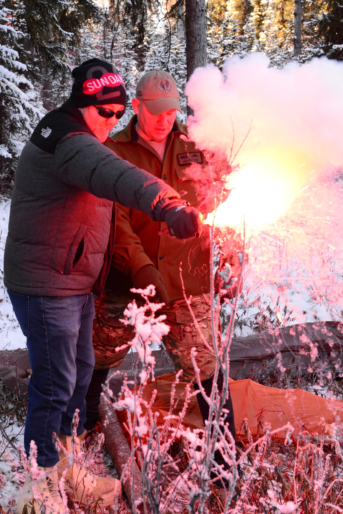Jason Taylor, left, president of a production company, ignites a flare under the supervision of U.S. Air Force Staff Sgt. Jonathan Case, a 66th Training Squadron Det. 1 survival, evasion, resistance and escape specialist Oct. 25, 2016, at Eielson Air Force Base, Alaska. Taylor learned about Arctic Survival School and ways to signal for help if he got stranded in the arctic. (U.S. Air Force photo by Airman Eric M. Fisher)