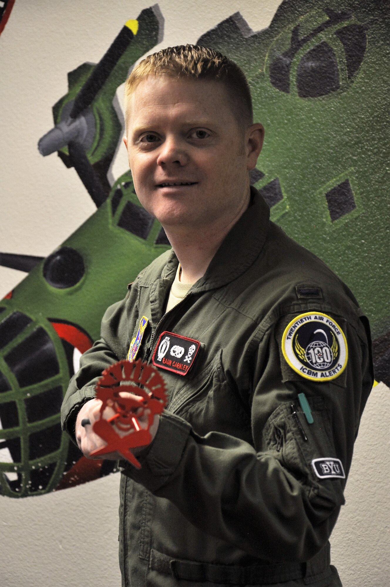 First Lt. Raun Carnley, 320th Missile Squadron missile combat crew commander shows off one of the new 20th Air Force alert milestone patches at F.E. Warren Air Force Base, Wyo., Oct. 27, 2016. Carnley’s design was selected among several others for the entire missileer community. 