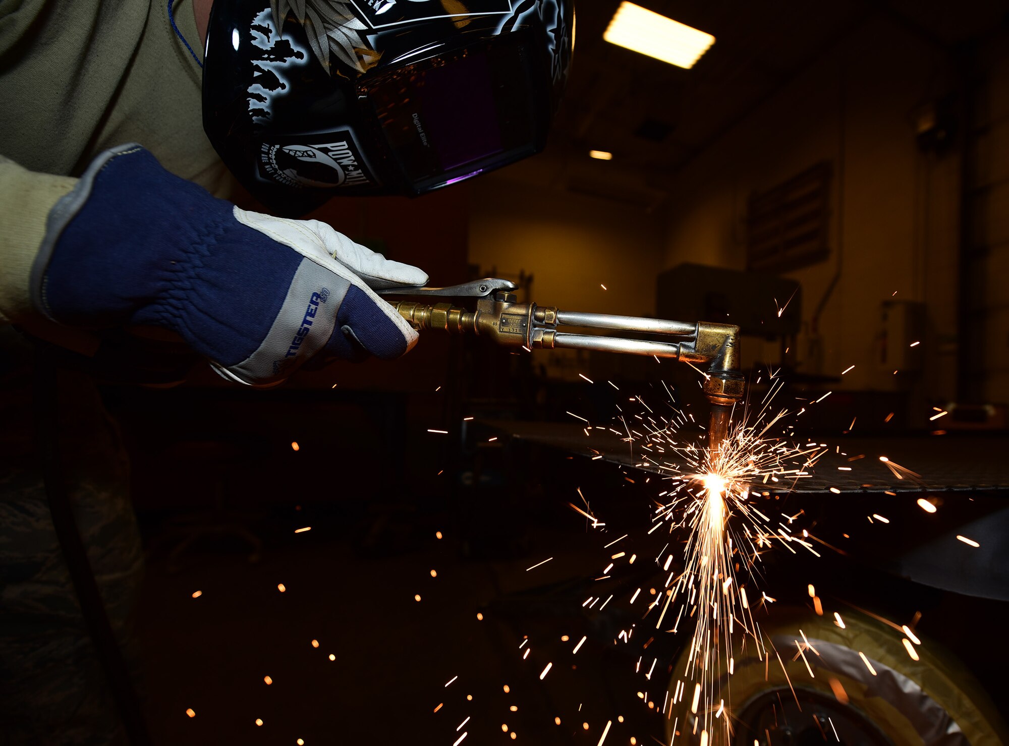 Senior Airman Kyle Eberhart, an aircraft metals technology journeyman assigned to the 28th Maintenance Squadron, torches through a piece of diamond plate sheet metal for a munitions trailer at Ellsworth Air Force Base, S.D., Oct. 27, 2016.  Mandatory safety equipment, such as flame resistant gloves, long pants and a welding mask, must be worn to protect against high temperatures and brightness from the torch. (U.S. Air Force photo by Airman 1st Class James L. Miller)