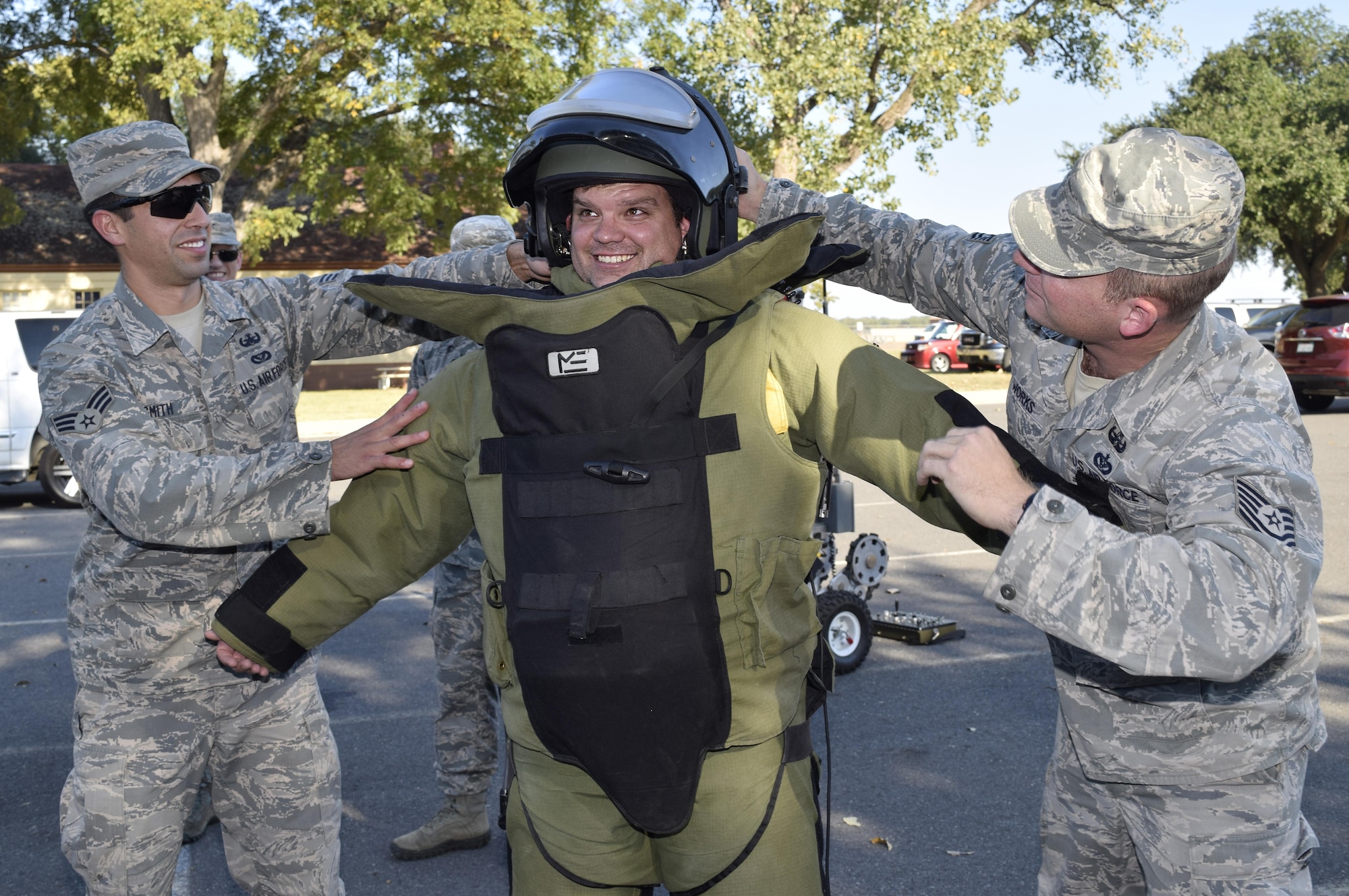 Senior Airman J. Michael Smith left, and Tech. Sgt. Paul Works, right, both with the 2nd Civil Engineer Squadron Explosive Ordnance Disposal flight, secure Matthew Haby of Haby Reality into an EOD 9 bomb suit Oct. 27, 2016 at Barksdale Air Force Base,  Louisiana. The demonstration was part of a civic leader tour sponsored by the 433rd Airlift Wing and hosted by the 307th Bomb Wing. (U.S. Air Force photo by Tech. Sgt. Lindsey Maurice)  