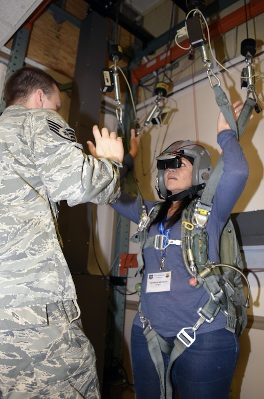 Staff Sgt. Travis Tidwell, 2nd Operations Support Squadron aircrew flight equipment technician, explains to Patricia Revollo, Starbucks district manager, how the parachute simulator works before starting the demonstration Oct. 28, 2016 at Barksdale Air Force Base, Texas. The demonstration was part of a civic leader tour sponsored by the 433rd Airlift Wing and hosted by the 307th Bomb Wing. (U.S. Air Force photo by Tech. Sgt. Lindsey Maurice)  