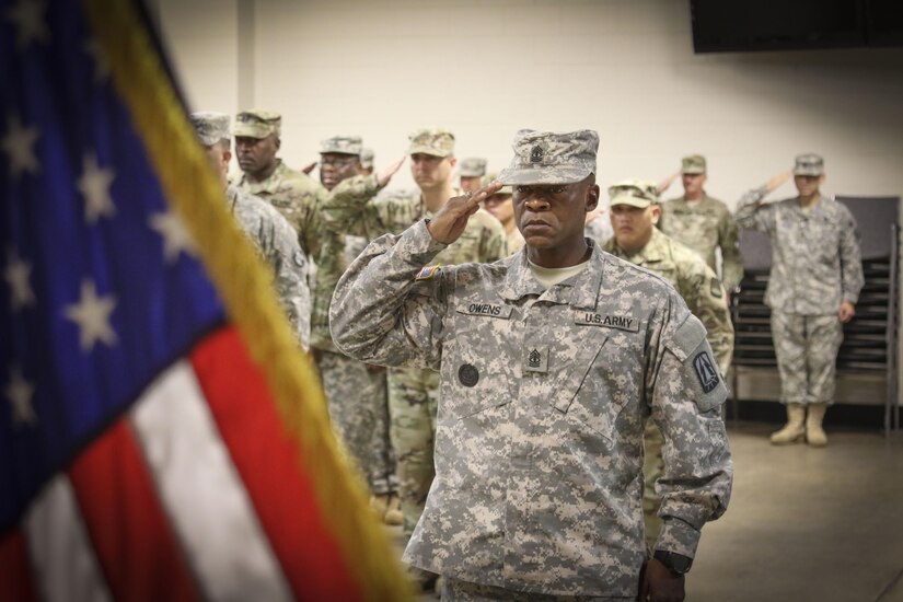 1st Sgt. Benjamin L. Owens, detachment first sergeant, Detachment 4, 335th Signal Command (Theater) salutes the American flag during the playing of the National Anthem at a deployment ceremony for him and nearly 70 Army Reserve Soldiers at the unit headquarters in East Point, Georgia Oct. 30. The Soldiers are preparing to deploy to Southwest Asia in support of Operation Inherent Resolve.  (Photo by Sgt. 1st Class Brent C. Powell)