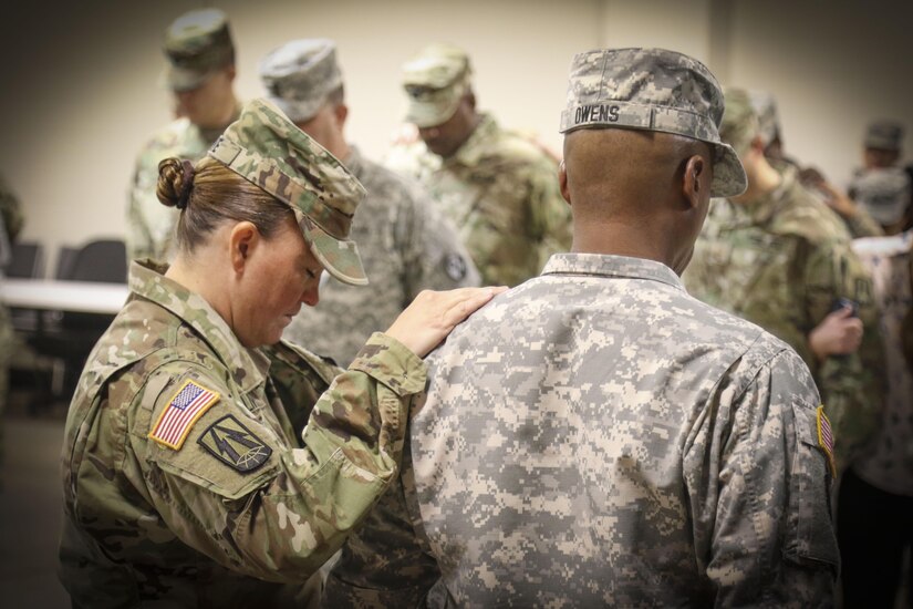 Col. Nikki Olive-Griffin (left), deputy commanding general of sustainment, 335th Signal Command (Theater) pauses for a moment of prayer with 1st Sgt. Benjamin L. Owens, first sergeant of Detachment 4, 335th SC (T) during a deployment ceremony held at the unit headquarters Oct. 30 for nearly 70 Army Reserve Soldiers who are preparing to deploy to Southwest Asia in support of Operation Inherent Resolve.  (Photo by Sgt. 1st Class Brent C. Powell)