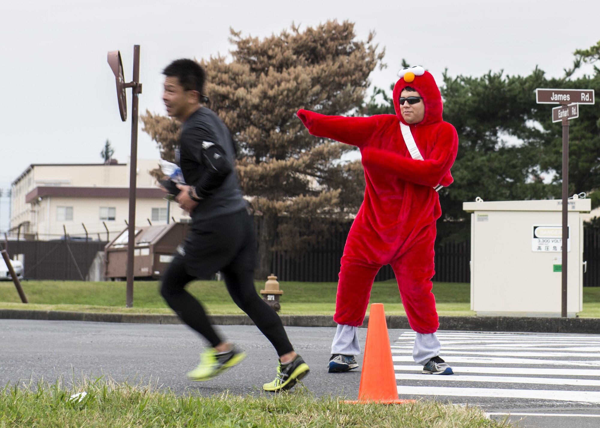 A volunteer in a Halloween costume directs event participants to the finish line during the 5th annual 374th Civil Engineer Squadron Running of the Bulls 10K on 28 Oct. 2016, at Yokota Air Base, Japan. Event volunteers ensured participant safety by directing traffic along the course and operating a mobile hydration station. (U.S. Air Force photo by Airman 1st Class Donald Hudson/Released)
