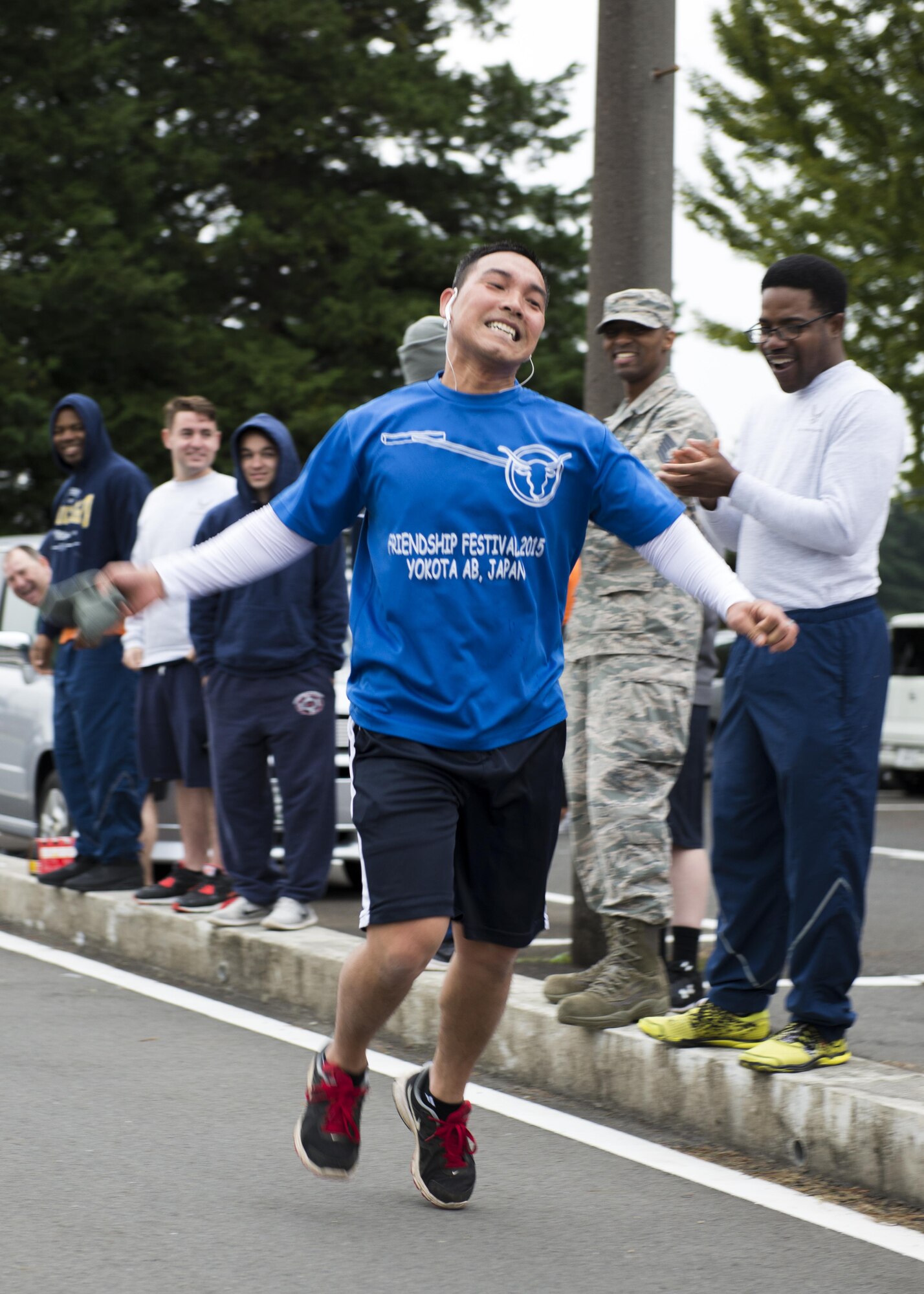 A race participant shows his excitement as he crosses the finish line during the 5th annual 374th Civil Engineer Squadron Running of the Bulls 10K on 28 Oct. 2016, at Yokota Air Base, Japan. The event had over 75 participants and raised $760 for charity. (U.S. Air Force photo by Airman 1st Class Donald Hudson/Released)
