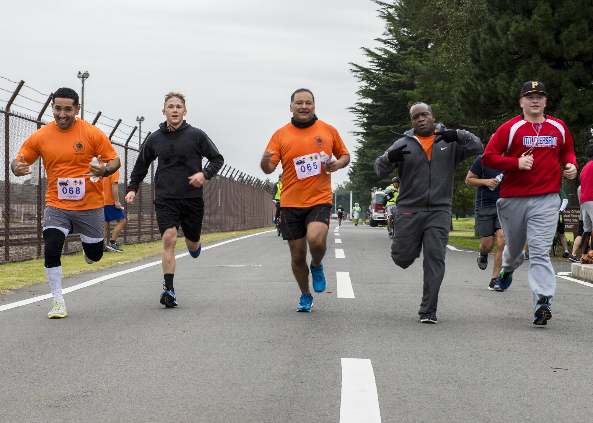 Participants cross the finish line together during the 5th annual 374th Civil Engineer Squadron Running of the Bulls 10K on 28 Oct. 2016, at Yokota Air Base, Japan. The event had over 75 participants and raised $760 for charity. (U.S. Air Force photo by Airman 1st Class Donald Hudson/Released)