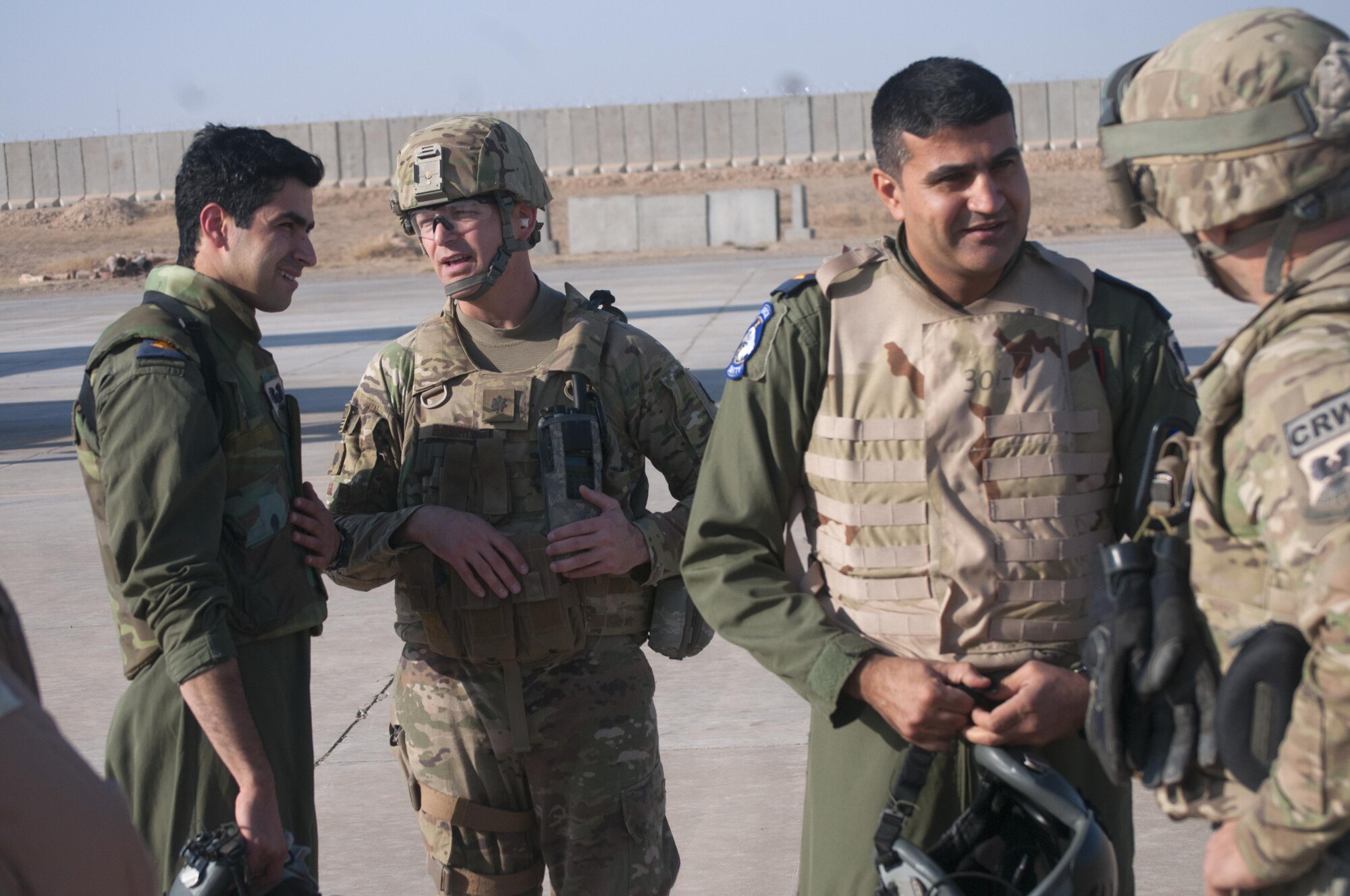 U.S. Air Force Lt. Col. Blaine Baker, left, director of tactical operations center operations, 821st Crisis Response Group, speaks with a pilot of an Iraqi air force C-130J Super Hercules after their landing at Qayyarah West Airfield, Iraq, Oct. 30, 2016. This was the first time a fixed wing aircraft from the Iraqi security forces landed at Qayyarah West Airfield since the base was occupied by Islamic State of Iraq and the Levant in 2014. Coalition forces reconstructed the airfield as part of their effort to assist the Iraqi security forces as the seize territory from ISIL. The Qayyarah West Airfield serves as a logistics hub for ongoing operations in northern Iraq. (U.S. Army photo by 1st Lt. Daniel Johnson)