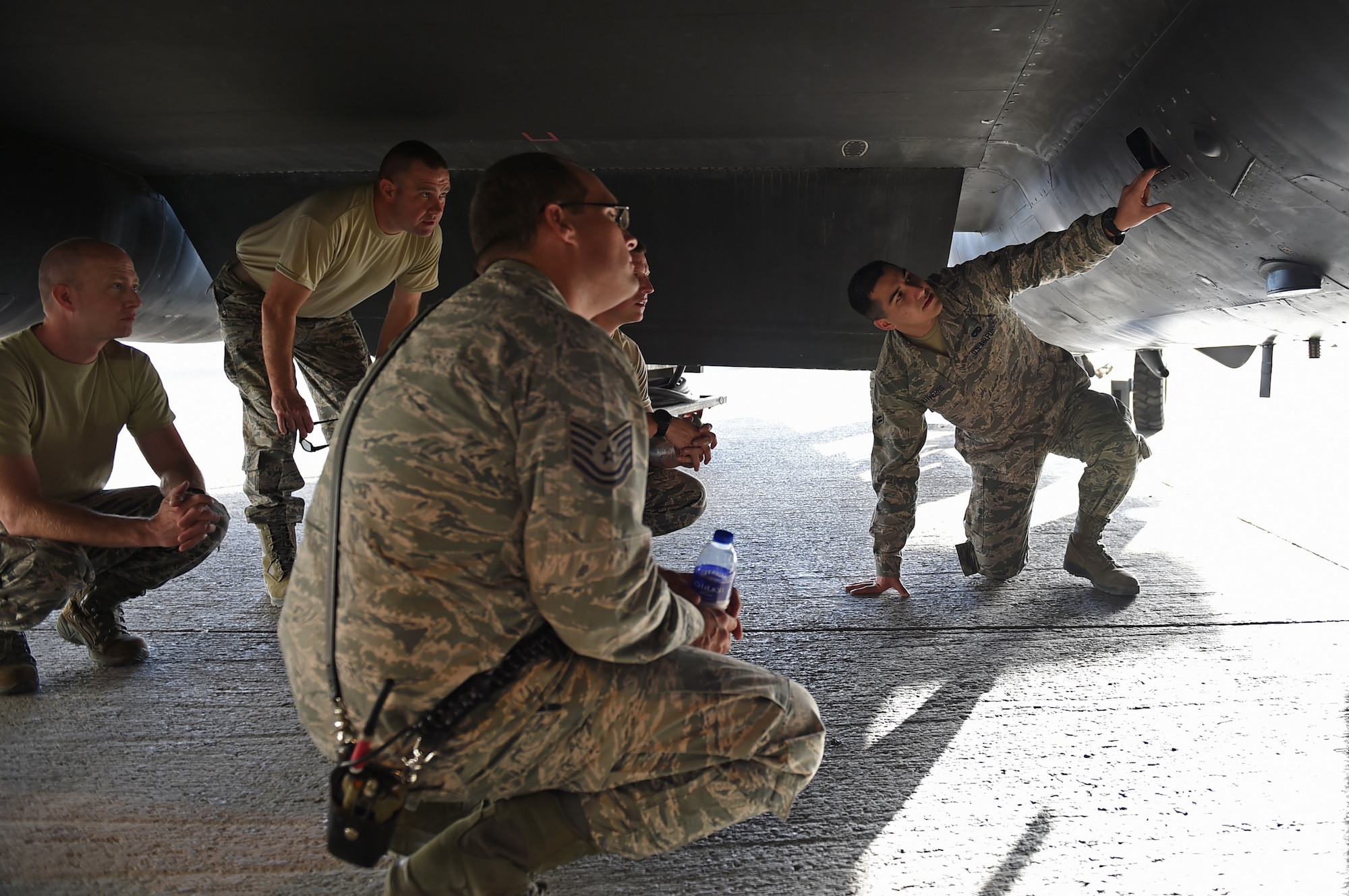 Airman 1st Class Jesus, 380th Expeditionary Aircraft Maintenance Squadron, points out the blow down door on the side of a U-2 Dragon Lady to members of the 380th Expeditionary Civil Engineer Squadron Fire Department during training at an undisclosed location in Southwest Asia, Oct. 27, 2016. The blow down door is one of a few primary locations that need to be checked in the event of a suspected hydrazine leak. (U.S. Air Force photo by Tech. Sgt. Christopher Carwile)