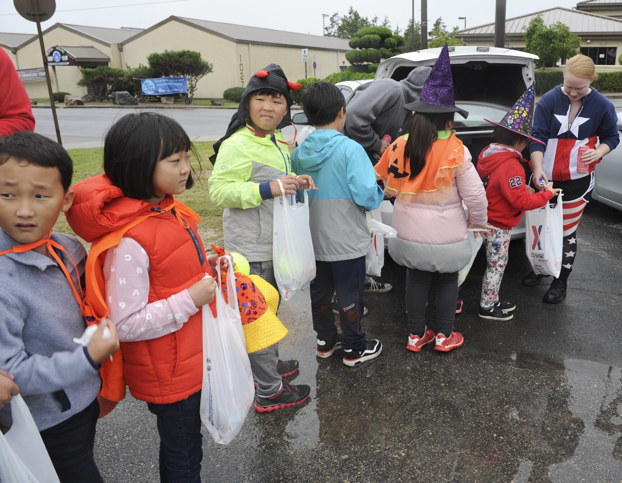 Children from Sinsido elementary school wait in line to receive candy from Airman 1st Class Jamie Cline, 8th Aircraft Maintenance Squadron crew chief, at Kunsan Air Base, Republic of Korea, Oct.28, 2016. The children participated in a base tour that included a trick-or-treat Halloween event. (U.S. Air Force photo by Senior Airman Michael Hunsaker/Released)