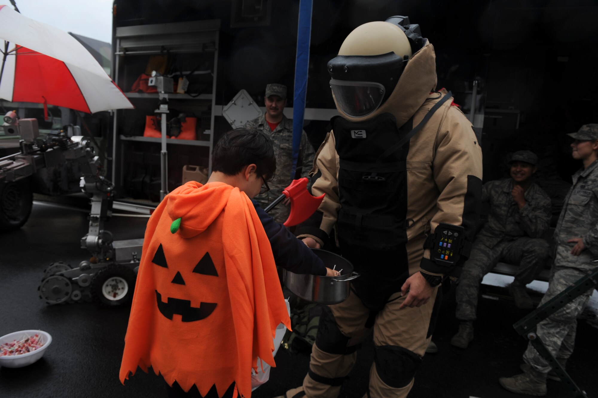 Senior Airman Steven James, 8th Civil Engineering Squadron explosive ordinance disposal technician, hands out candy to children from Sinsido elementary school at Kunsan Air Base, Republic of Korea, Oct. 28, 2016. The children participated in a base tour that included a trick-or-treat Halloween event. (U.S. Air Force photo by Senior Airman Michael Hunsaker/Released)