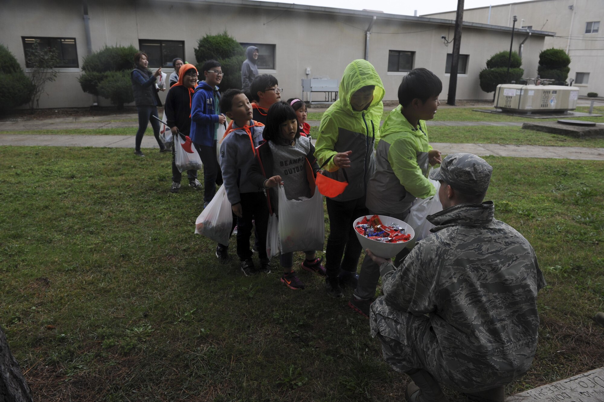 Maj. John Marshall, 8th Civil Engineering engineering flight commander, hands out candy to children from Sinsido elementary school at Kunsan Air Base, Republic of Korea, Oct. 28, 2016. The children participated in a base tour that included a trick-or-treat Halloween event. (U.S. Air Force photo by Senior Airman Michael Hunsaker/Released)