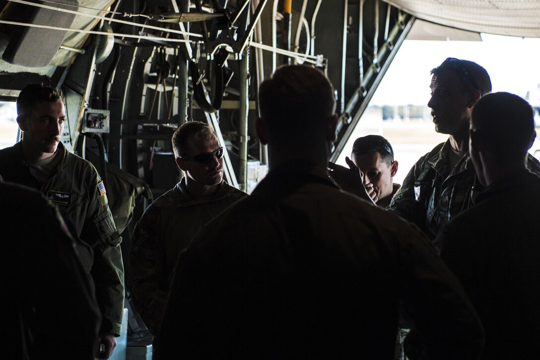 Air Force airmen coordinate with pilots in the cargo area of a C-130 Hercules aircraft before a personnel airdrop training exercise at Yokota Air Base, Japan, Oct. 26, 2016. The airmen are survival, evasion, resistance and escape specialists assigned to the 374th Operations Support Squadron. Air Force photo by Airman 1st Class Donald Hudson