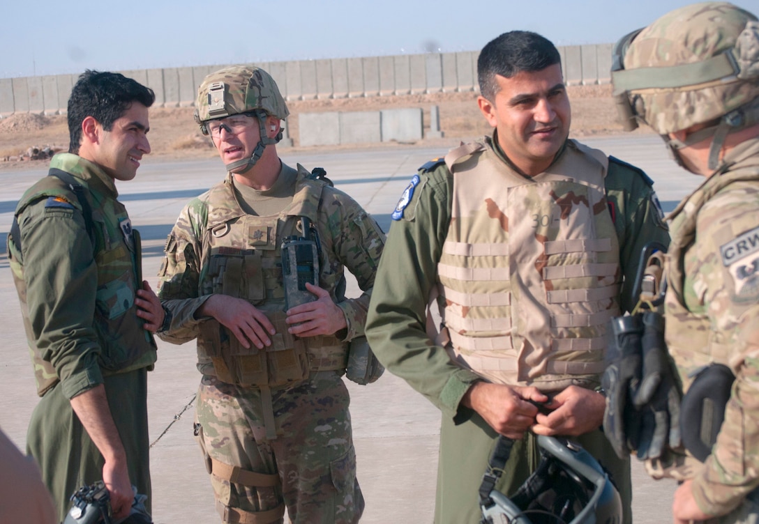U.S. Air Force Lt. Col. Blaine Baker, left, director of tactical operations center operations, 821st Crisis Response Group, speaks with a pilot of an Iraqi air force C-130J Super Hercules after their landing at Qayyarah West Airfield, Iraq, Oct. 30, 2016. This was the first time a fixed wing aircraft from the Iraqi security forces landed at Qayyarah West Airfield since the base was occupied by Islamic State of Iraq and the Levant in 2014. Coalition forces reconstructed the airfield as part of their effort to assist the Iraqi security forces as the seize territory from ISIL. The Qayyarah West Airfield serves as a logistics hub for ongoing operations in northern Iraq. (U.S. Army photo by 1st Lt. Daniel Johnson)