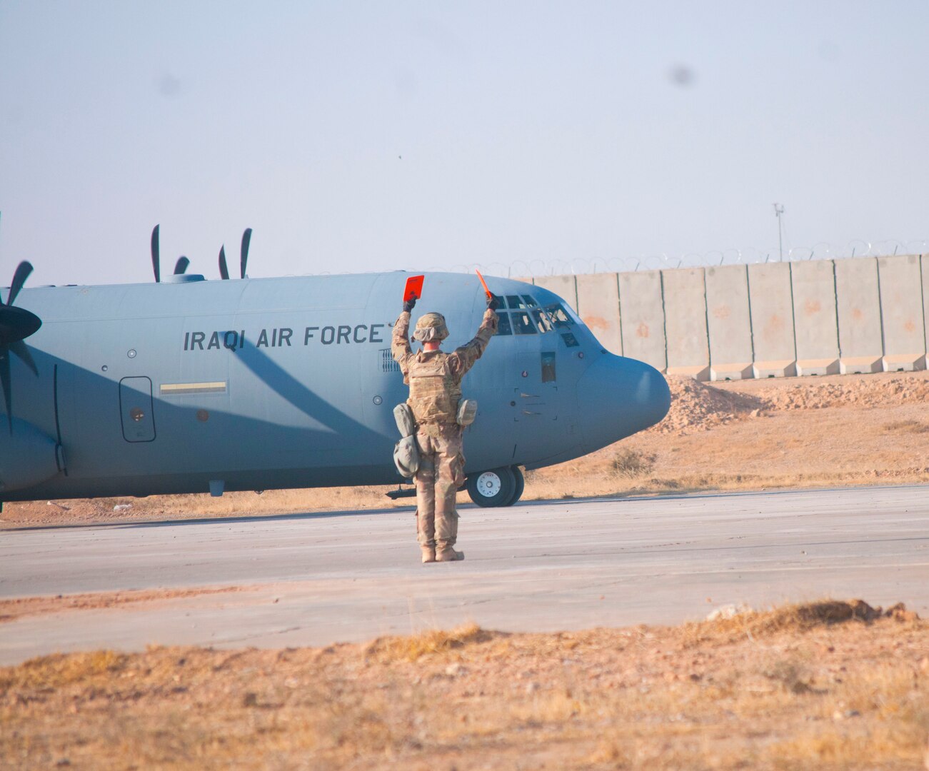 A U.S. Air Force Airman with the 821st Crisis Response Group, signals a taxing Iraqi air force C-130J Super Hercules at Qayyarah West Airfield, Iraq, Oct. 30, 2016. This was the first time a fixed wing aircraft from Iraqi security forces landed at Qayyarah West Airfield since the base was occupied by Islamic State of Iraq and the Levant in 2014. Coalition forces reconstructed the airfield as part of their effort to assist the Iraqi security forces as the seize territory from ISIL. Qayyarah West Airfield serves as a logistics hub for ongoing operations in northern Iraq. (U.S. Army photo by 1st Lt. Daniel Johnson)