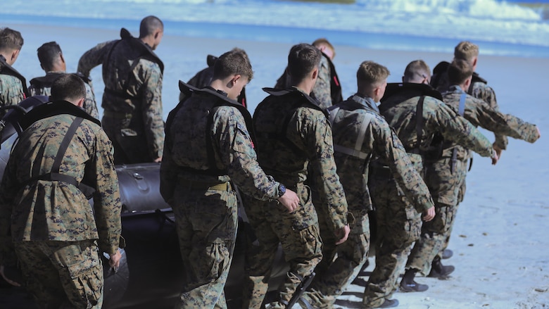 Marines with 2nd Reconnaissance Battalion carry a zodiac boat into the waves of Onslow Beach at Camp Lejeune, N.C., Oct. 20, 2016. These Marines conducted helocasting, practicing being inserted from a helicopter with a zodiac boat as well as a movement to shore without a boat for a scout swimmer fin insertion. 