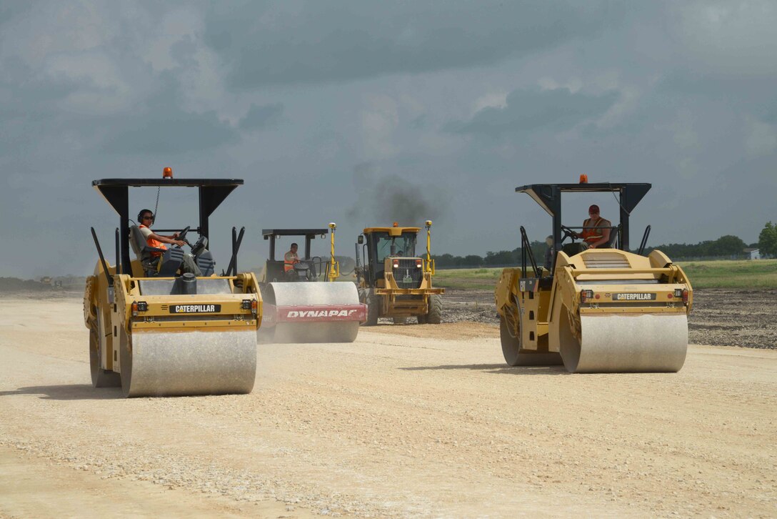 Heavy equipment operators from the Air Force’s 820th Rapid Engineer Deployable Heavy Operational Repair Squadron Engineer operate tandem vibratory rollers on a new runway surface June 23 at Joint Base San Antonio-Randolph's Seguin Auxiliary Airfield. DLA Troop Support’s Construction and Equipment supply chain provided 40,000 tons of asphalt for the runway construction. 