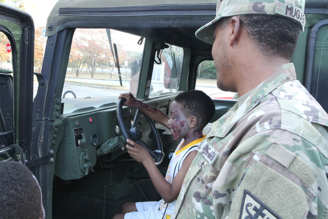 Sgt. Mugabo gave Church Street Elementary School students a chance to climb into a military vehicle during the Trunk or Treat event where 3d MCDS Soldiers handed out Halloween candy from the back of the Humvee.