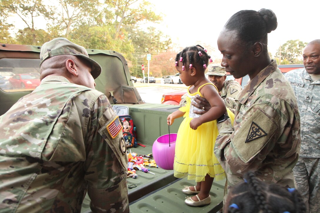 Capt. Boahema, 3d MCDS HHC Commander and soldiers from the 3d MCDS help a little girl choose Halloween candy during the Trunk or Treat event held at Church Street Elementary School.